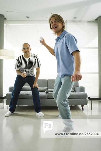 Zwei Männer spielen Videospiele mit kabellosen Controllern