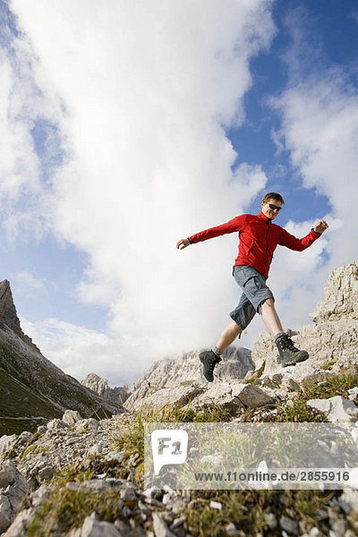 Man jumping from rock to rock