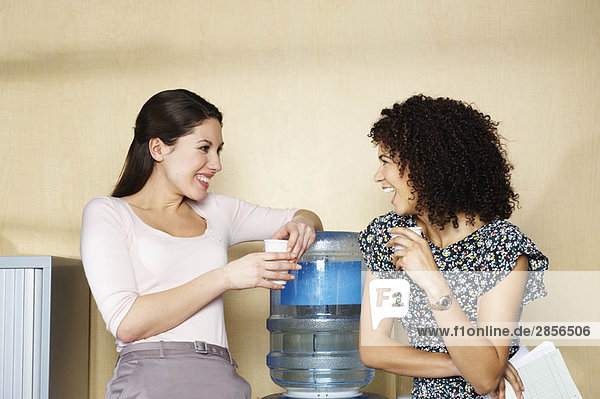 Zwei Frauen lachen am Wasserspender