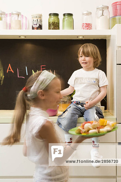 Mädchen und Junge kochen Gemüse