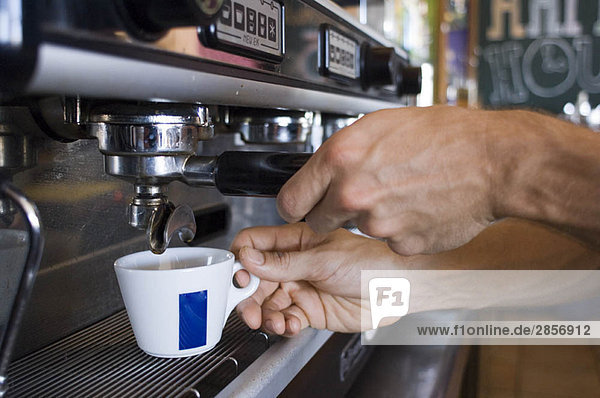 Nahaufnahme der Hände beim Kaffeekochen