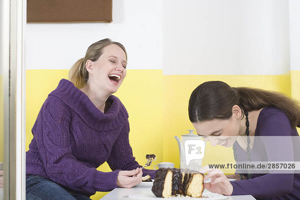 Zwei junge Frauen auf dem Tisch  lachend