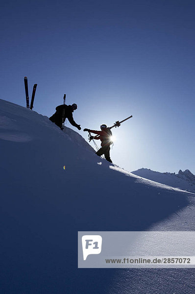 Skifahrer helfen sich gegenseitig am Berg