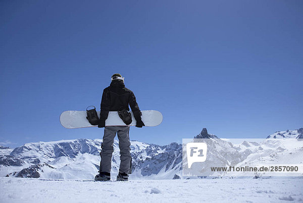 Mann auf dem Berg stehend mit Snowboard