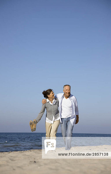 Mature couple walking along beach