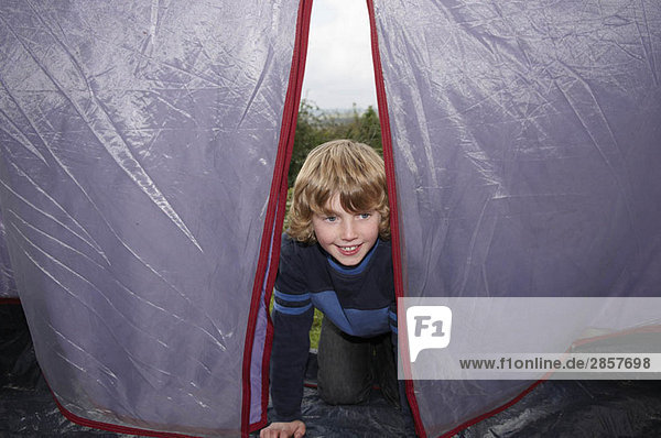 Junge klettert ins Zelt