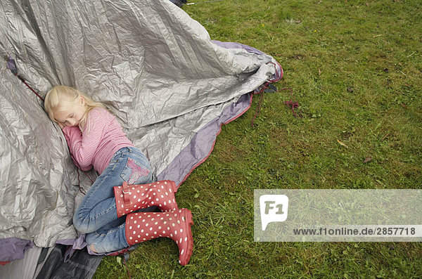 Mädchen schläft auf dem Zelt