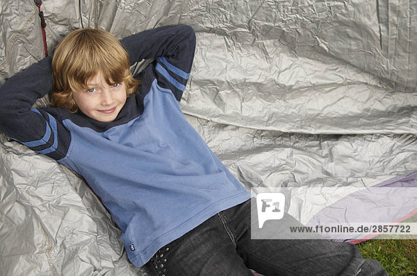 Junge ruht auf Zelt