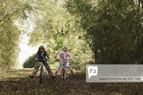 Junge und Mädchen beim Radfahren auf dem Land