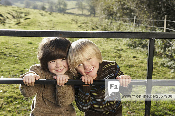 Zwei kleine Jungen am Tor auf dem Lande