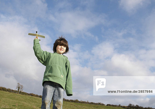 Young Boy mit Spielzeugflugzeug im Feld