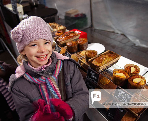 Mädchen am Bäckerei-Stand auf dem Markt