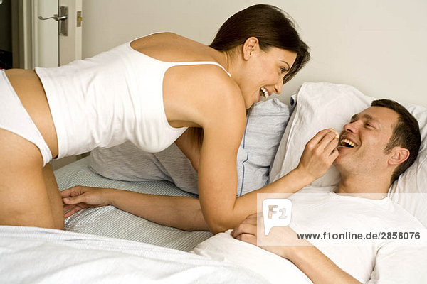 Young couple at home relaxing in bed