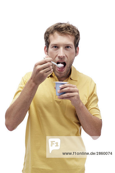 Joghurt essender junger Mann  Porträt