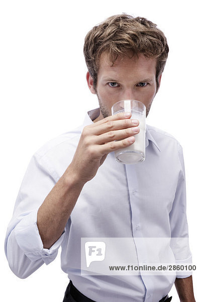 Junger Mann trinkt ein Glas Milch,  Porträt