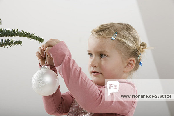 Kleines Mädchen (3-4) mit Weihnachtskugel
