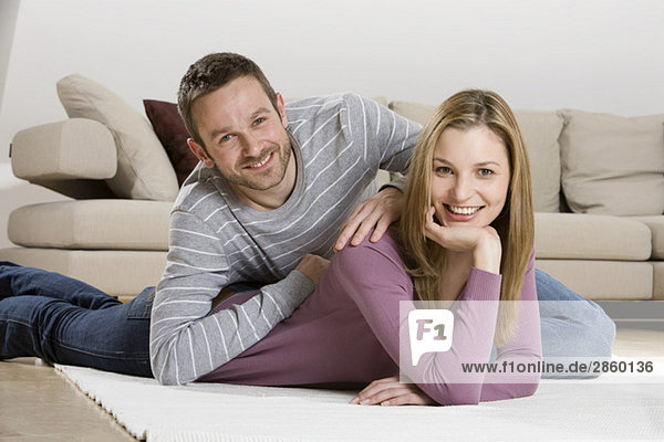 Young couple relaxing on carpet