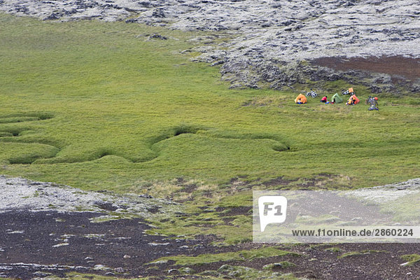 Island  Mountainbiker beim Ausruhen auf Rasen