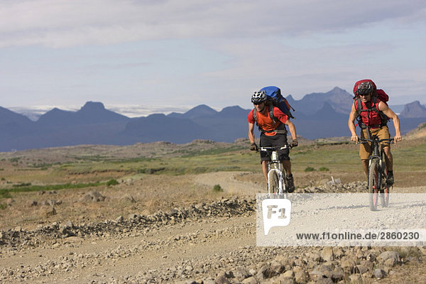 Iceland  Men mountain biking in hilly landscape
