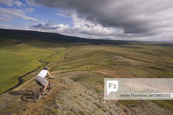 Iceland  Man mountain biking across hilly landscape