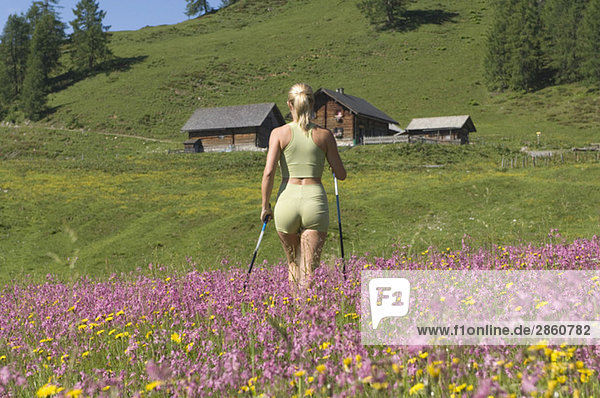 Österreich  Salzburger Land  Junge Frau  Nordic Walking  Rückansicht