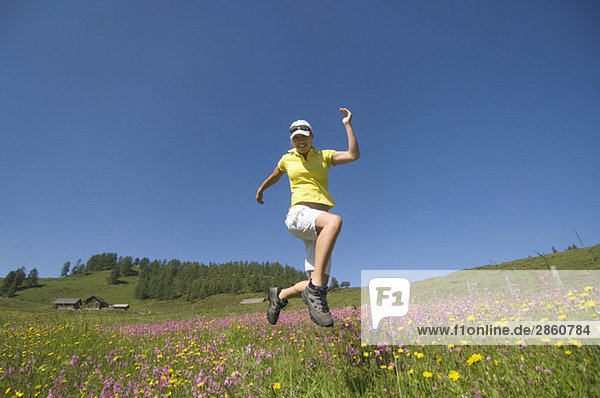 Austria  Salzburger Land  Young woman running across meadow