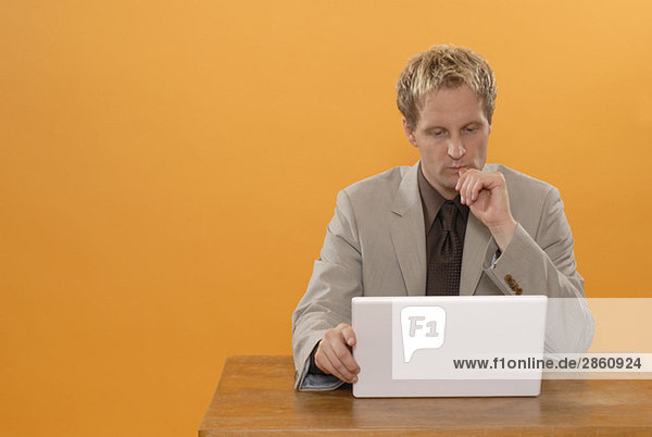 Man sitting at laptop  musing  portrait