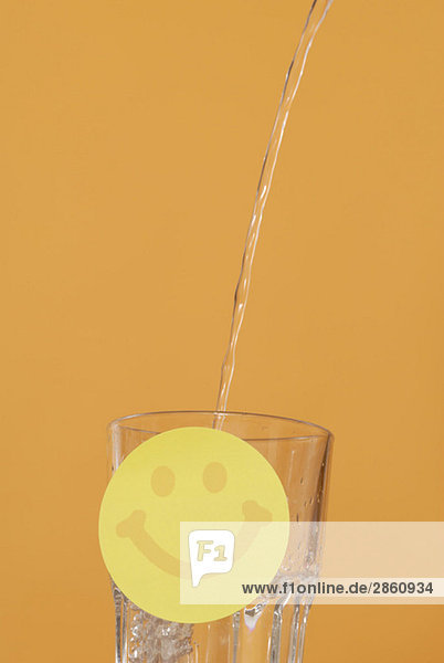 Water being poured into glass  Smiley in foreground