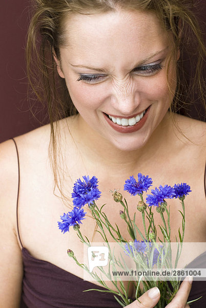 Young woman holding cornflowers  portrait  close up