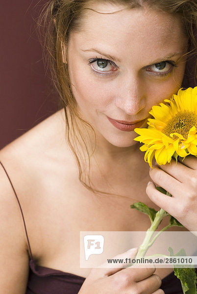 Young woman holding sunflower  portrait  close up