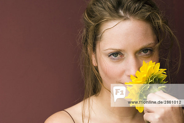 Junge Frau mit Sonnenblume  Portrait  Nahaufnahme