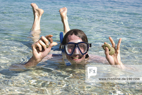 Greece  Ithaca  Man wearing diving mask  holding shells  portait