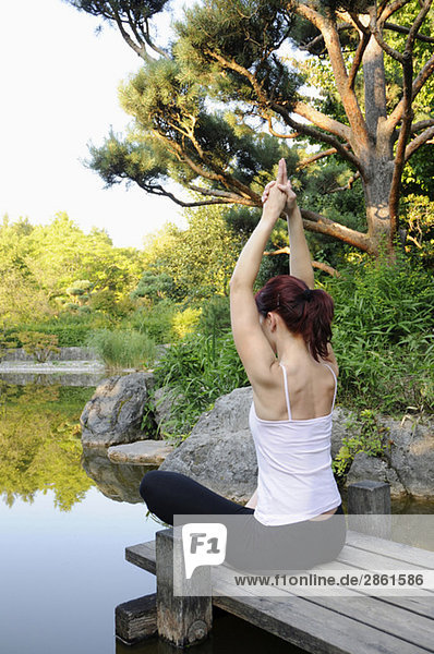 Junge Frau beim Yoga  Rückansicht