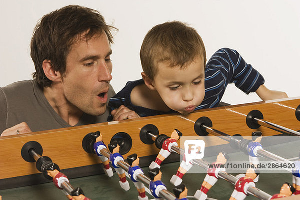 Vater und Sohn (4-5) spielen Tischfußball  Nahaufnahme
