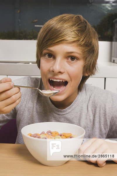 Teenage boy (14-15) having muesli for breakfast  smiling  portrait