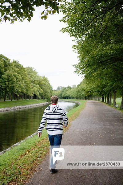 Ein Mann zu Fuß neben einem Kanal Schweden.