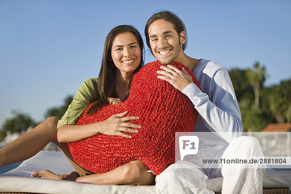 Porträt eines Paares mit einem herzförmigen Kissen