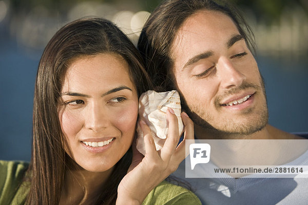 Couple listening to a shell