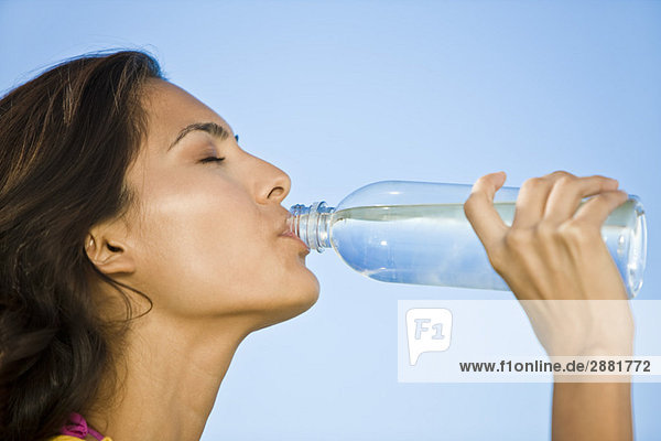 Frau trinkt Wasser aus einer Wasserflasche
