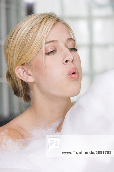 Frau beim Blasen in der Badewanne