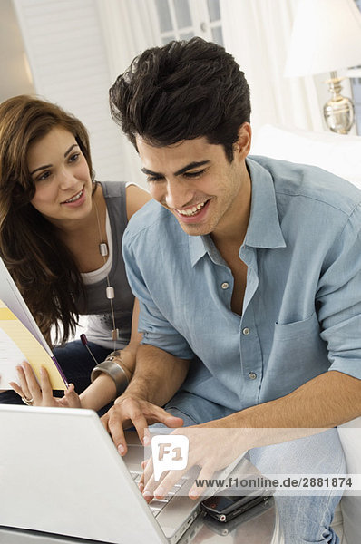 Couple using a laptop and smiling