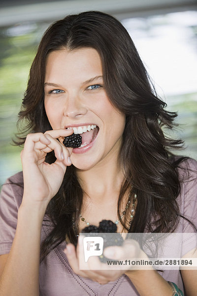 Portrait of a woman eating blackberries