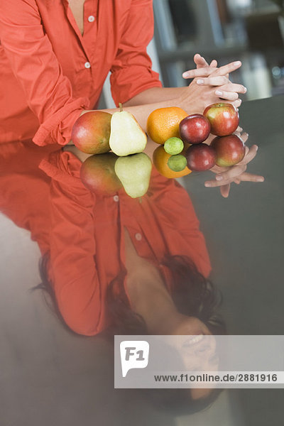 Spiegelung einer Frau und Früchte auf einer Küchentheke
