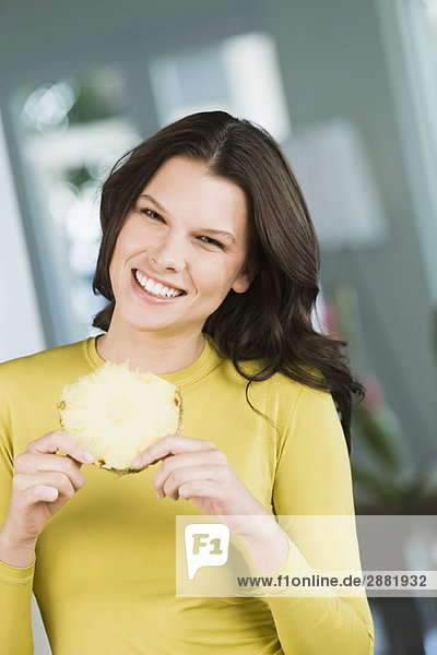 Woman holding a slice of pineapple