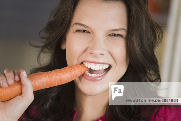 Frau beim Essen einer Karotte