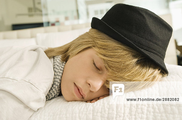 Teenager-Junge schläft auf dem Bett