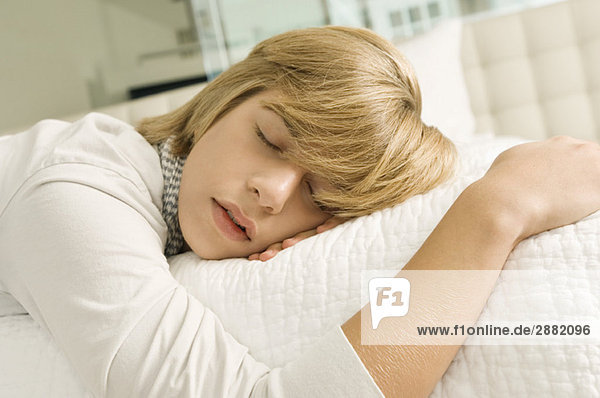 Teenager-Junge schläft auf dem Bett
