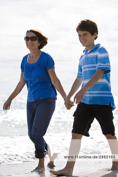 Frau mit ihrem Enkel beim Spaziergang am Strand