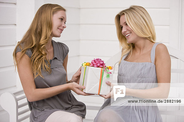Frau schenkt ihrer Freundin ein Geschenk