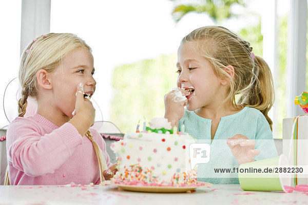 Zwei Mädchen essen Geburtstagstorte